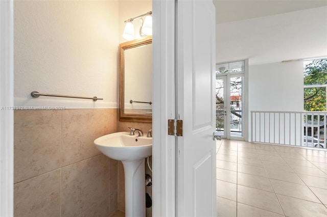 bathroom featuring tile patterned flooring, sink, and tile walls