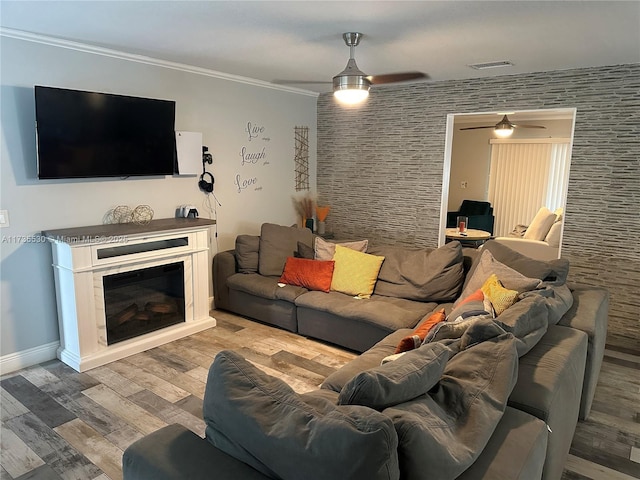 living room featuring crown molding, ceiling fan, and light hardwood / wood-style floors