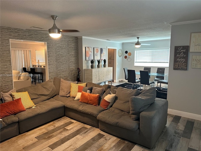 living room featuring hardwood / wood-style flooring, crown molding, and ceiling fan