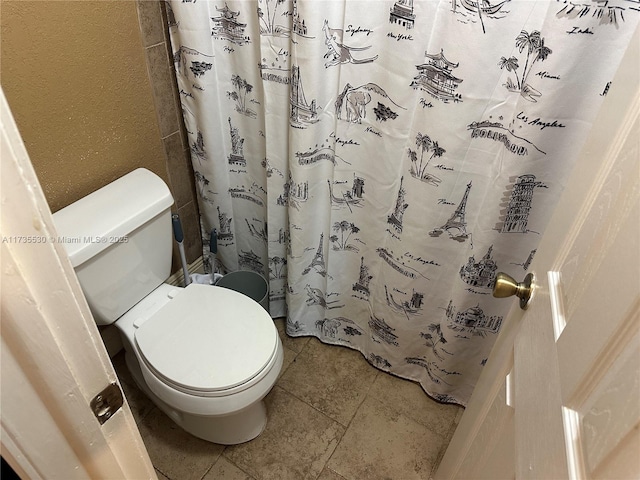 bathroom with a shower with curtain and toilet