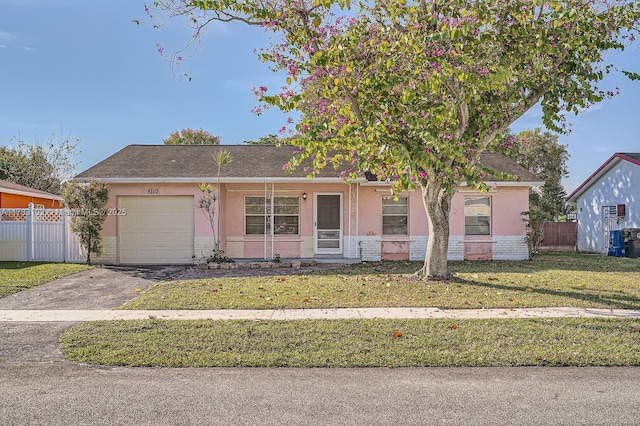 single story home featuring a garage and a front lawn