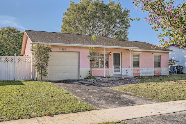 single story home with a garage and a front lawn