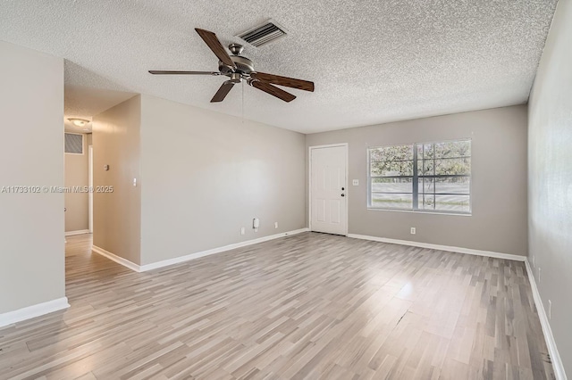 unfurnished room with ceiling fan, light hardwood / wood-style flooring, and a textured ceiling