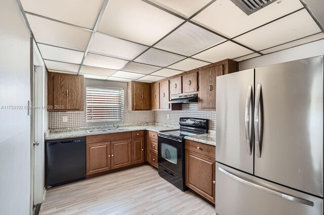 kitchen featuring tasteful backsplash, sink, a paneled ceiling, and black appliances