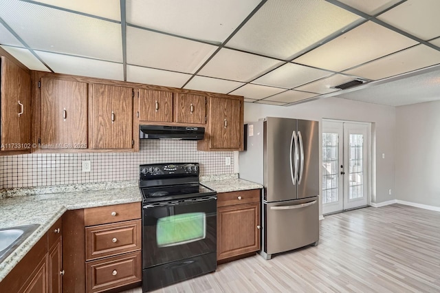 kitchen with black electric range oven, stainless steel fridge, backsplash, light hardwood / wood-style floors, and french doors