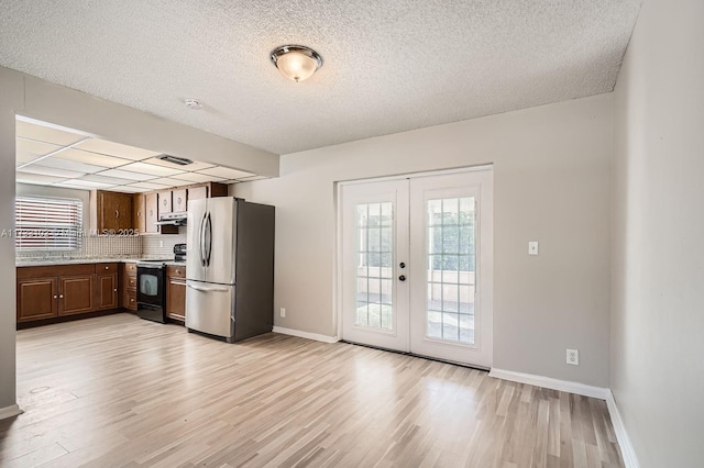 kitchen featuring french doors, light hardwood / wood-style flooring, stainless steel fridge, and black range with electric cooktop