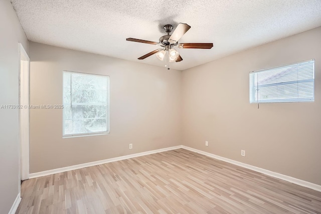 empty room featuring ceiling fan, a textured ceiling, and light hardwood / wood-style flooring