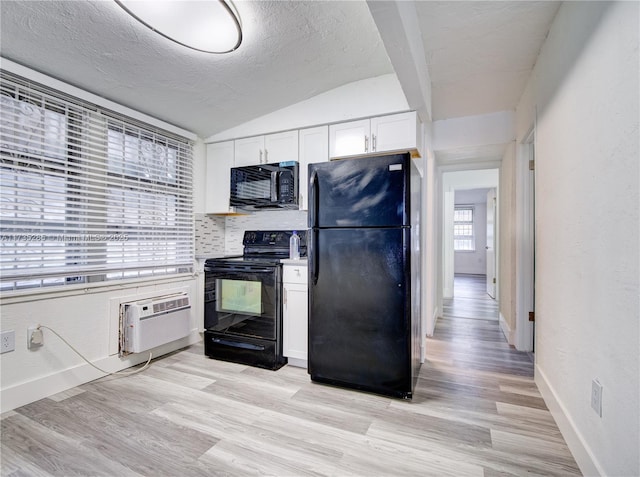 kitchen with white cabinets, light hardwood / wood-style flooring, a wall unit AC, and black appliances