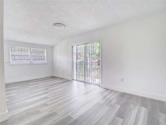 unfurnished room featuring light hardwood / wood-style floors and a textured ceiling