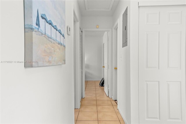 corridor featuring electric panel and light tile patterned floors