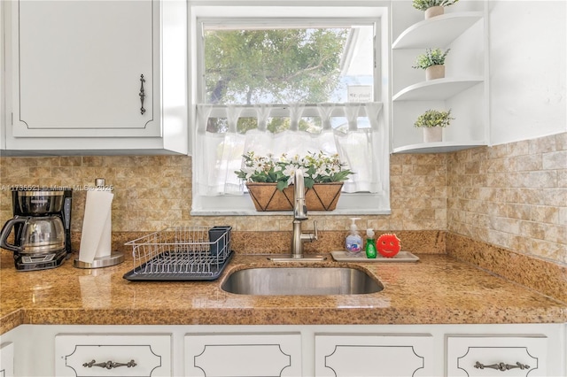 kitchen with white cabinetry, sink, and tasteful backsplash