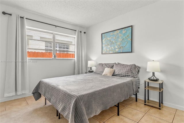 bedroom with light tile patterned floors and a textured ceiling