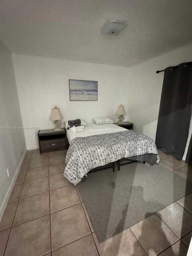 tiled bedroom with a textured ceiling