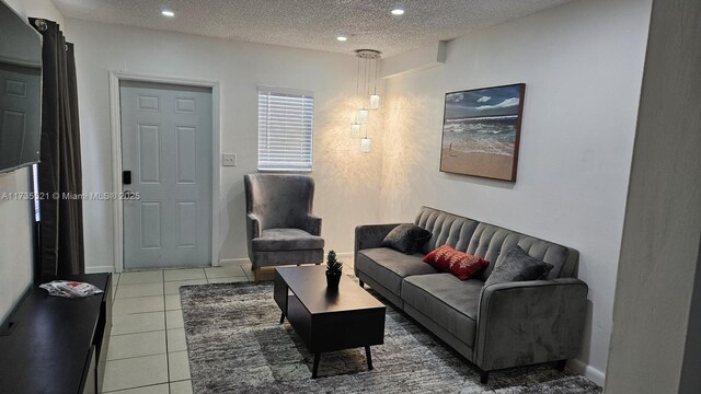 tiled living room featuring a textured ceiling