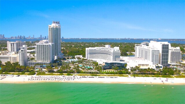 birds eye view of property with a water view and a beach view