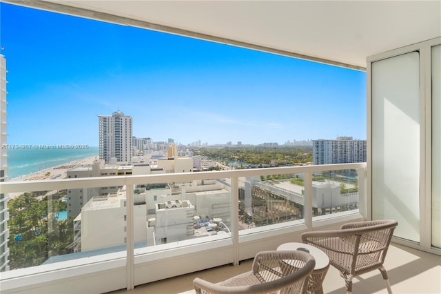 balcony featuring a water view and a view of the beach