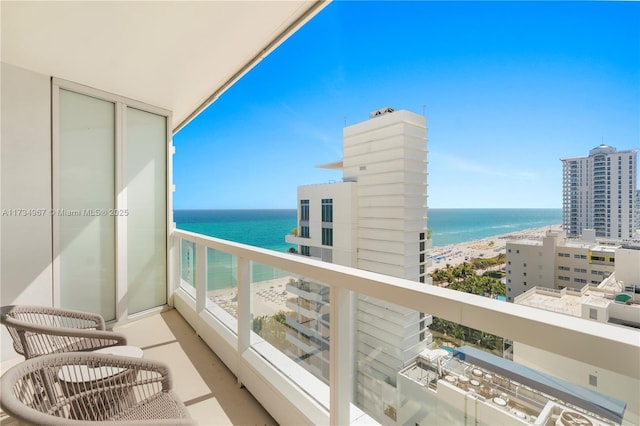 balcony featuring a water view and a beach view