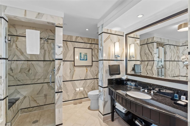 bathroom with tile walls, an enclosed shower, vanity, and toilet