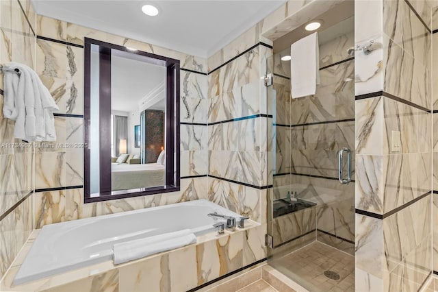 bathroom featuring plus walk in shower and tile walls