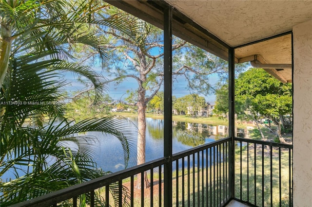 unfurnished sunroom featuring a water view