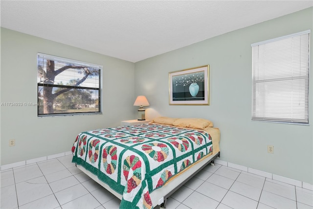 bedroom with light tile patterned floors and a textured ceiling