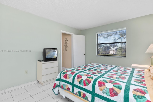 bedroom featuring a textured ceiling and light tile patterned floors