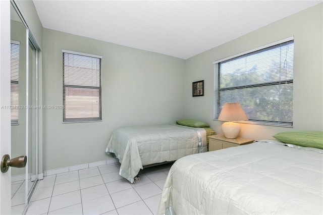 tiled bedroom featuring a textured ceiling