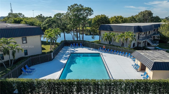 view of swimming pool featuring a patio and a water view