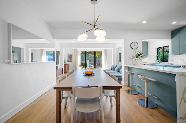 dining room with light wood-style floors, a wealth of natural light, and recessed lighting