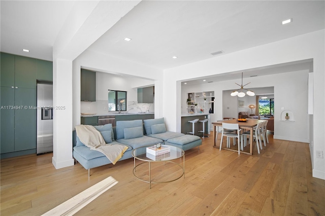 living area featuring recessed lighting, baseboards, visible vents, and light wood finished floors