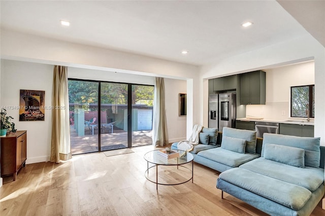 living room featuring recessed lighting, light wood-style flooring, and baseboards