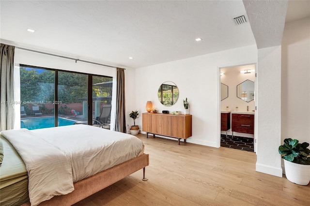 bedroom featuring visible vents, baseboards, ensuite bath, access to outside, and light wood-type flooring