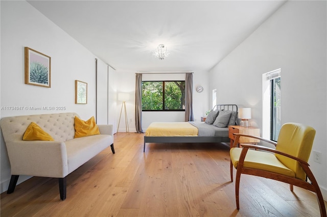 bedroom with a notable chandelier and light hardwood / wood-style flooring