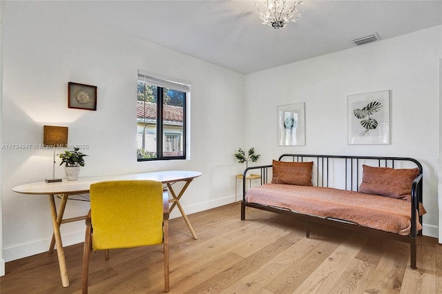 sitting room featuring a notable chandelier, hardwood / wood-style flooring, visible vents, and baseboards