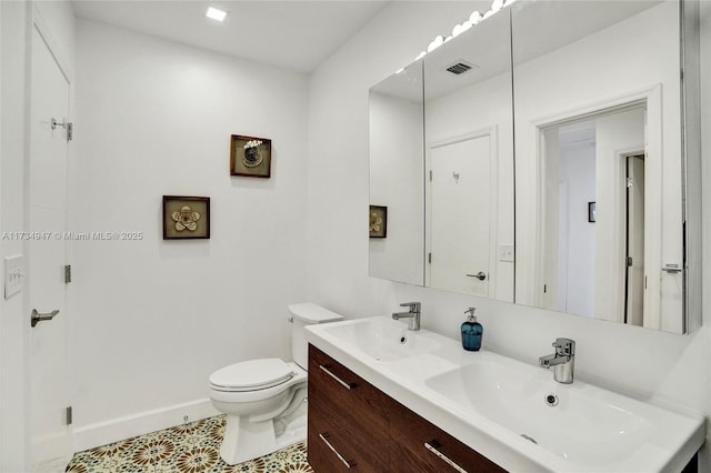 full bathroom featuring toilet, a sink, visible vents, and baseboards