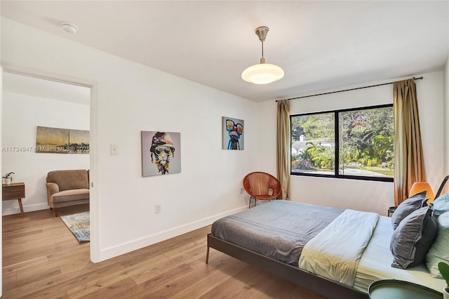 bedroom featuring light wood-style flooring and baseboards