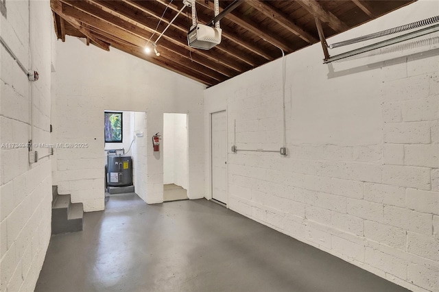 garage with a garage door opener and concrete block wall