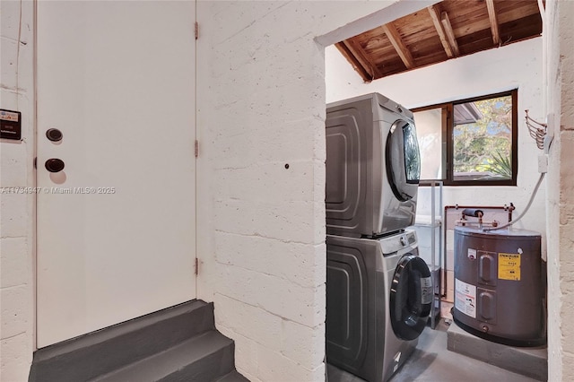 clothes washing area featuring water heater, laundry area, stacked washer / dryer, and wooden ceiling