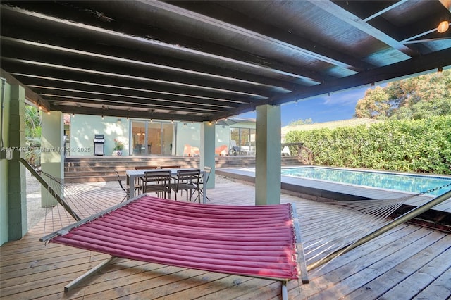 wooden deck with outdoor dining area and an outdoor pool