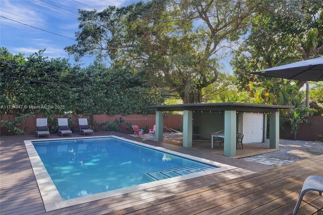 view of swimming pool featuring a deck, a fenced backyard, and a fenced in pool