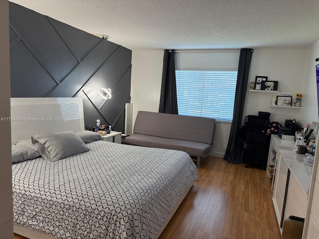 bedroom featuring hardwood / wood-style flooring and a textured ceiling