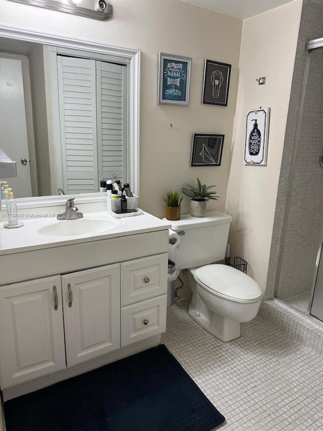 bathroom with vanity, toilet, an enclosed shower, and tile patterned flooring