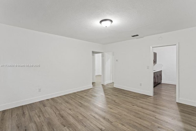 spare room with wood-type flooring and a textured ceiling