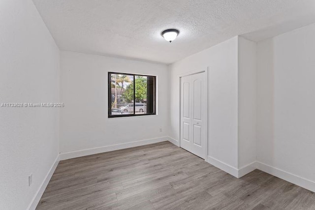 empty room featuring light hardwood / wood-style floors and a textured ceiling