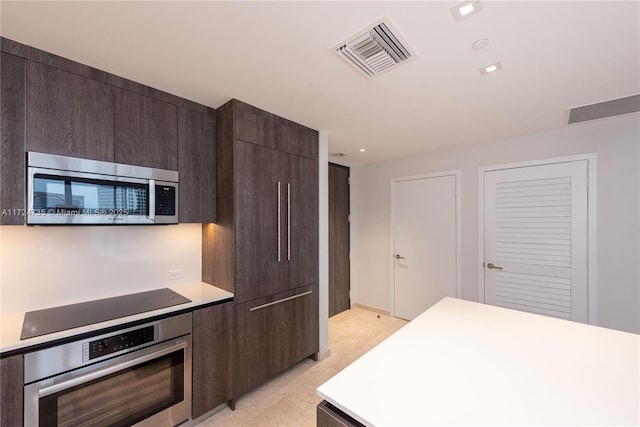 kitchen featuring stainless steel appliances and dark brown cabinets