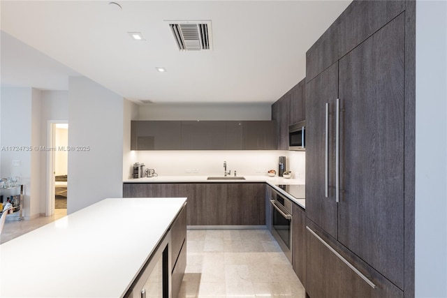 kitchen featuring dark brown cabinetry, sink, wine cooler, and appliances with stainless steel finishes