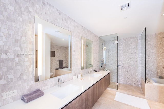 bathroom featuring tile patterned floors, shower with separate bathtub, tile walls, and vanity