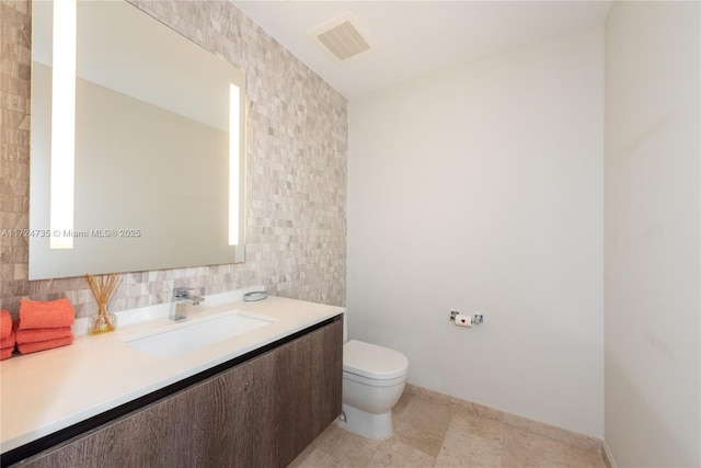 bathroom featuring vanity, decorative backsplash, tile walls, and toilet