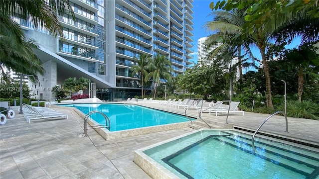 view of pool with a hot tub and a patio area