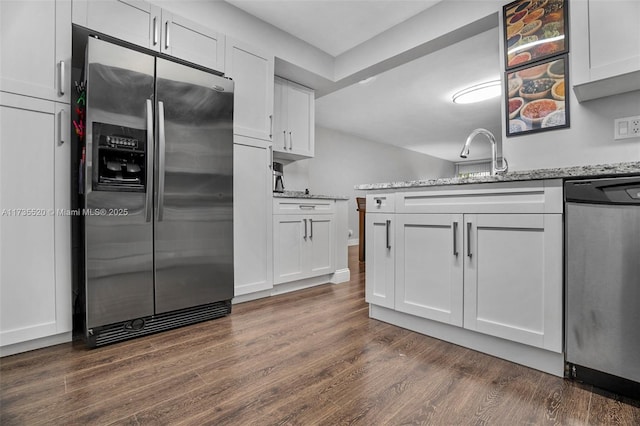 kitchen with white cabinetry, light stone countertops, and appliances with stainless steel finishes